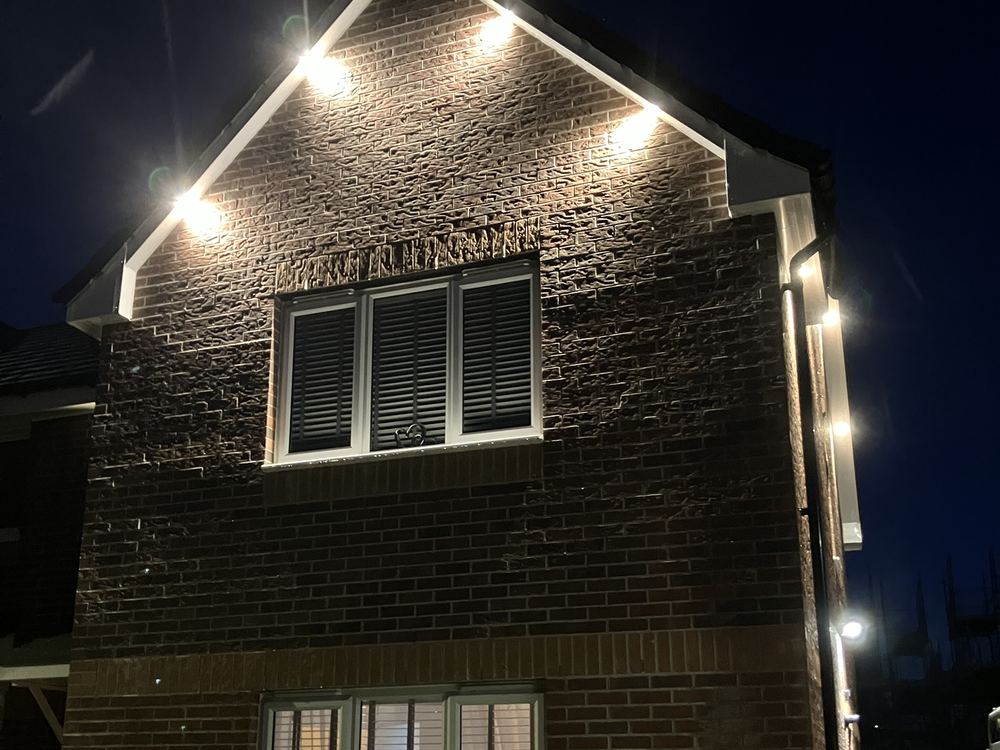 Gable-end soffit lights on a house at night