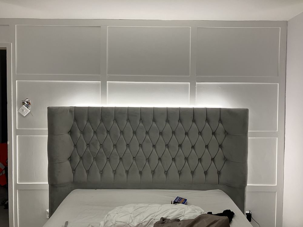 LED backlighting behind a bedroom headboard panel wall